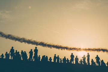 Fototapeta na wymiar Sunset silhouettes watching an airshow