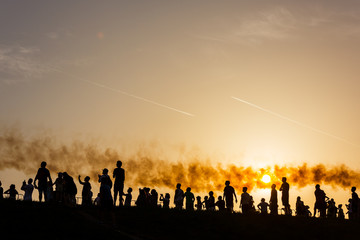 Fototapeta na wymiar Sunset silhouettes watching an airshow