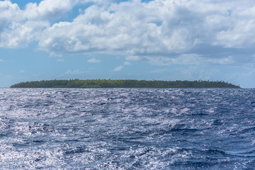 Desert island in French Polynesia, panorama from the Pacific ocean
