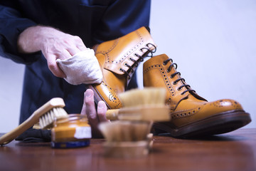 The process of cleaning shoes. A man is cleaning his shoes. - obrazy, fototapety, plakaty