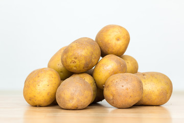 Eine Protion rohe Kartoffeln liegt auf einem Tisch vor weißem Hintergrund