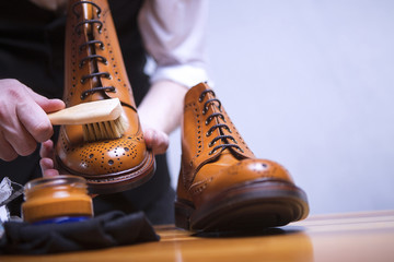 The process of cleaning shoes. A man is cleaning his shoes.