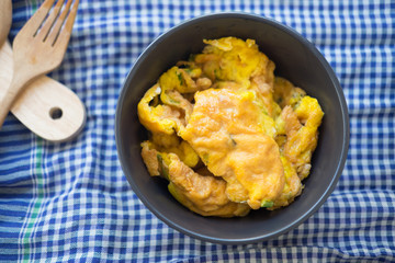 Omelet with vegetables in black bowl