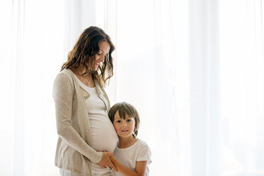Portrait of beautiful pregnant woman and her cute child