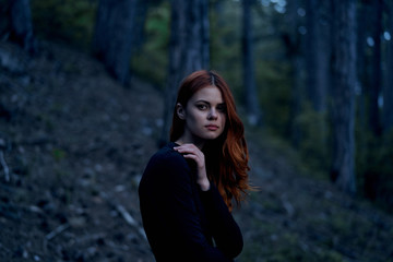 Beautiful young woman in a long dress in the forest