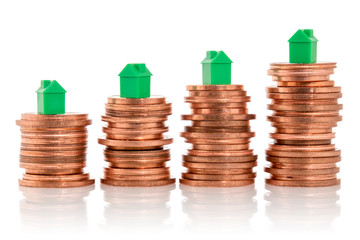 Stacked coins with mini houses on the top