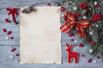 Christmas wood background with spruce branches, snow, red berries and ribbon bow