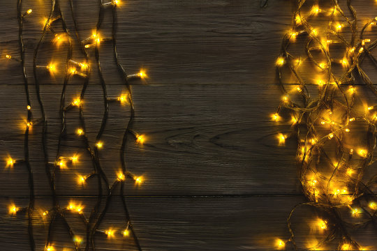 Christmas lights border on grey wooden background