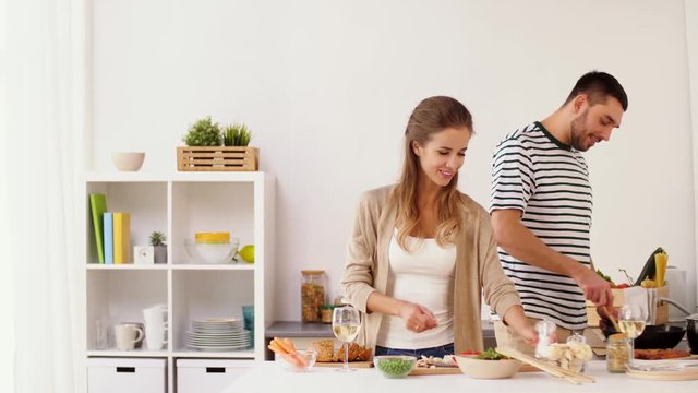 happy couple cooking food at home kitchen