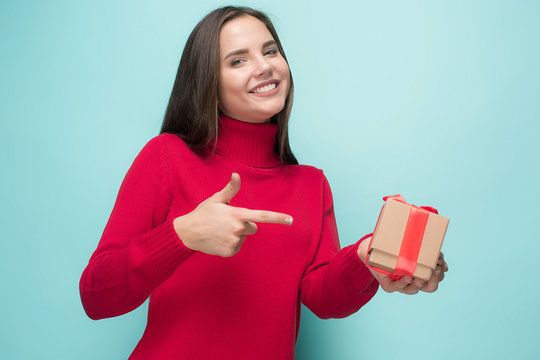 Portrait of happy young woman holding a gift isolated on white