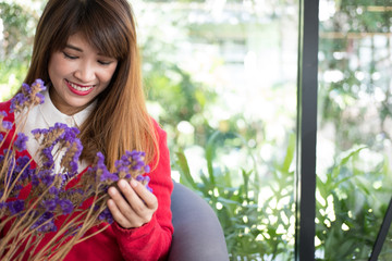 woman smiling while holding bouquet of purple flower.