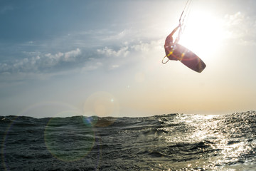 Surfer jumping at sunset over the golden sea