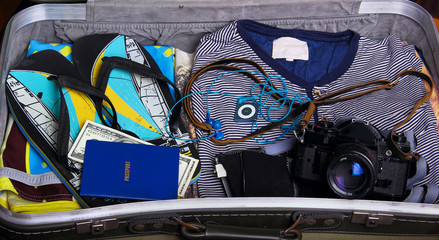 In suitcase: thongs, t-shirt, passport, money,camera music play
