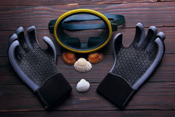 mask for diving with gloves for diving. Sea shell on the wooden background. top view.Symbol of...