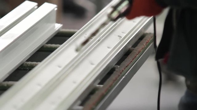 Factory for PVC windows and doors production. Workers in workshop. Manufacturing jobs. Factory Work on the production of PVC windows. PVC window production technology. Selective focus.