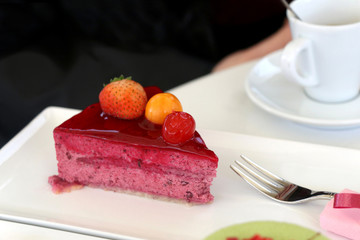 Slice of forest fruit cake and a cup of coffee. Selective focus. 