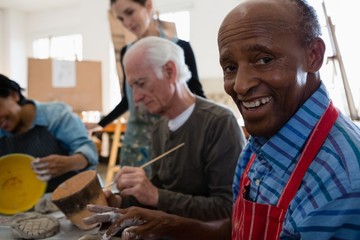 Close up portrait of senior man siting by friends
