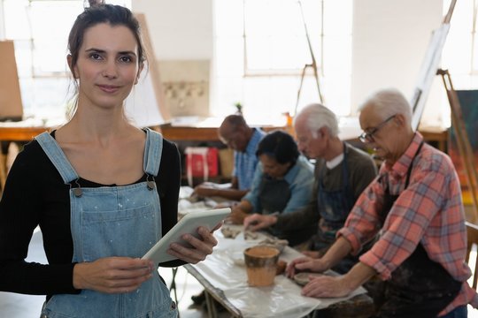 Portrait of female instructor holding table senior friends in