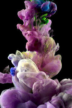Macro close-ups of colorful liquids that appeared for a brief second when the flow of color drops spread underwater. A colorful mix of fluids is Isolated on black background.