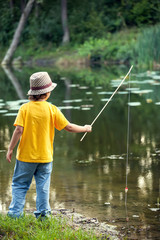 Happy boys go fishing on the river, Two children of the fisher with a fishing rod on the shore of lake