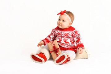 baby in a Christmas costume sits with gifts. beautiful New Year's presents