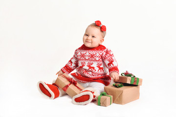 baby in a Christmas costume sits with gifts. beautiful New Year's presents