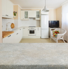 Empty kitchen stone table top with white modern kitchen in background