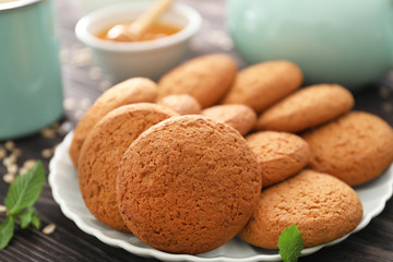 Plate with delicious oatmeal cookies on wooden table, closeup
