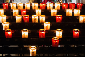 PARIS, FRANCE - FEBRUARY 1, 2017: Rows of firing lit votive candles inside Notre Dame de Paris, France.