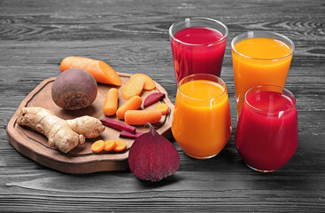 Glasses with various fresh juices and ingredients on table