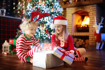 Fototapeta na wymiar Child at Christmas tree. Kids at fireplace on Xmas