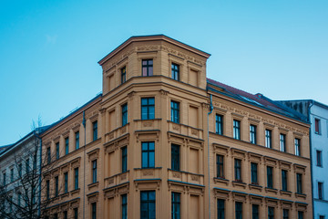 Fototapeta na wymiar orange corner building with high contrasted sky