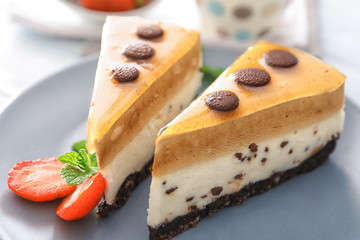 Pieces of layered mousse cake with caramel on plate, closeup