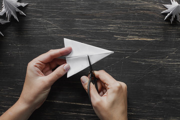 Sheet of paper with scissors on the black wooden table