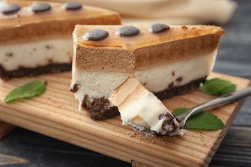 Piece of layered mousse cake with caramel on board