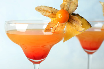 Glass with tasty exotic cocktail on light background, closeup