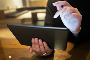 young woman using digital tablet surfing an internet or media