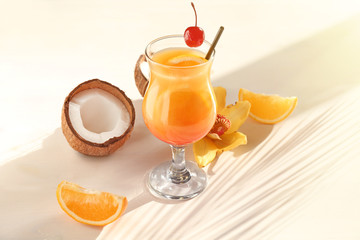 Glass with tasty exotic cocktail on table