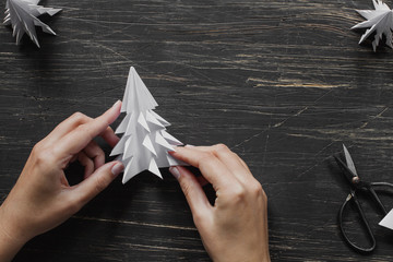 Hands making paper Christmas tree