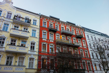 Obraz premium yellow, red and white houses in a row with stucco facade