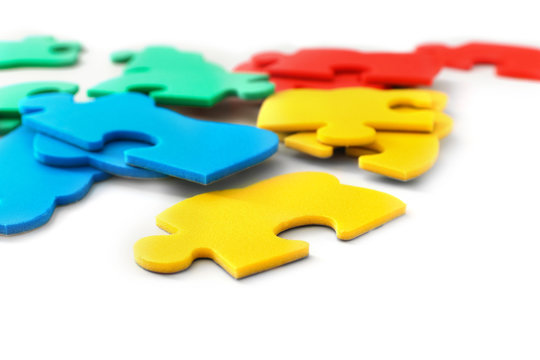 Pieces of colorful puzzle on light background. Autism awareness concept