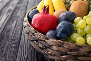 Basket and fresh fruits on wooden table