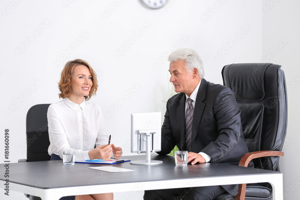 Wall mural Elderly man consulting young woman in office