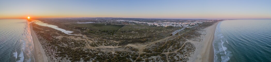 Aerial panoramic sunset seascape of famous Montegordo beach, Algarve.