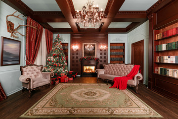 Christmas evening. classic apartments with a white fireplace, decorated tree, sofa, large windows and chandelier.