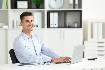 Attractive man with laptop in office
