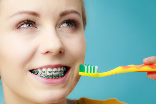 Woman with teeth braces using brush