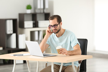 Obraz premium Attractive man with laptop in office