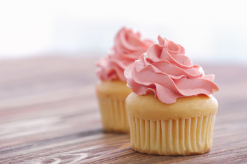 Delicious vanilla cupcakes on table
