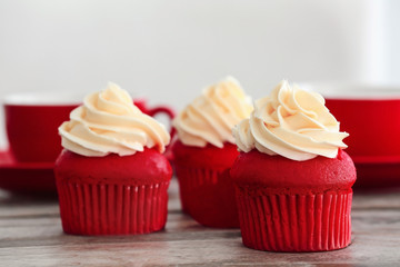 Delicious red velvet cupcakes on table